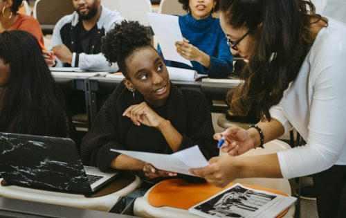 Female student and teacher discussing over test result in class