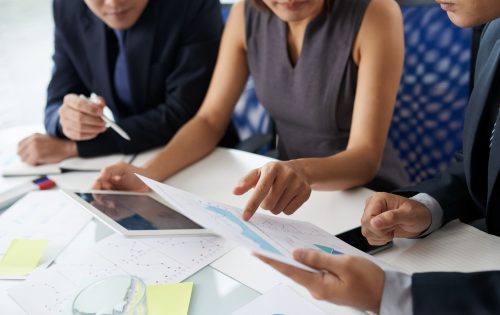 Entrepreneurs discussing charts and graphs at annual meeting